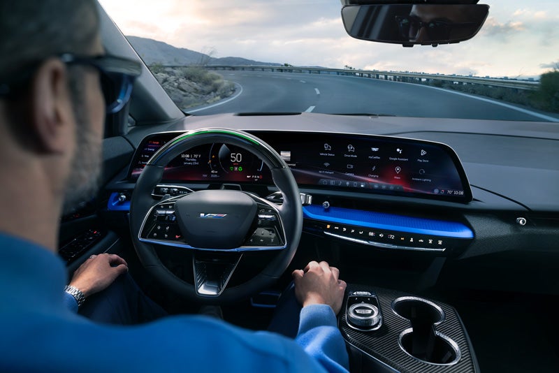 Front View of the 2026 OPTIQ-V Driving Through the Dusk Utilizing its Headlights | Lindsay Cadillac of Alexandria in Alexandria VA